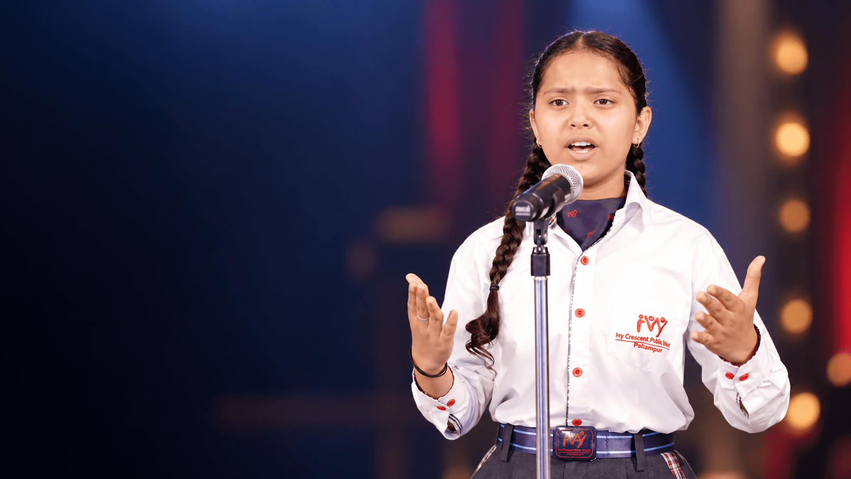 A student delivering a prepared talk on stage